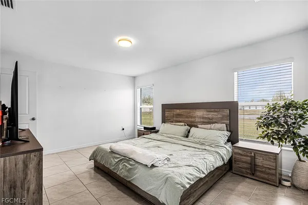 a bedroom with a bed and a potted plant