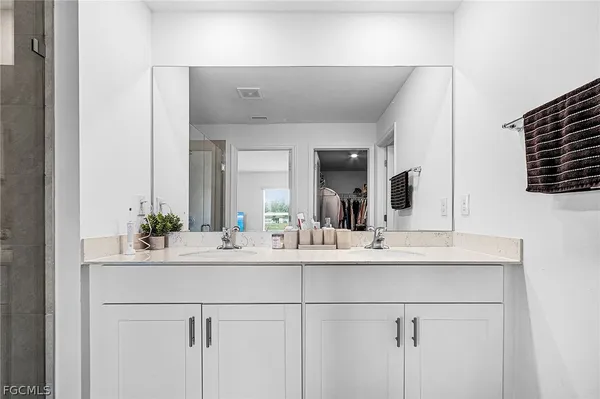 a bathroom with a double vanity sink and a mirror