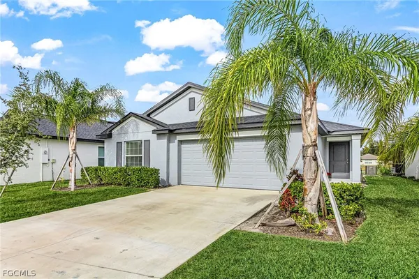 a view of a house with a yard and palm trees