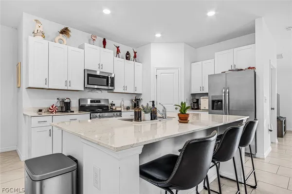 a kitchen with a sink a microwave a refrigerator and cabinets
