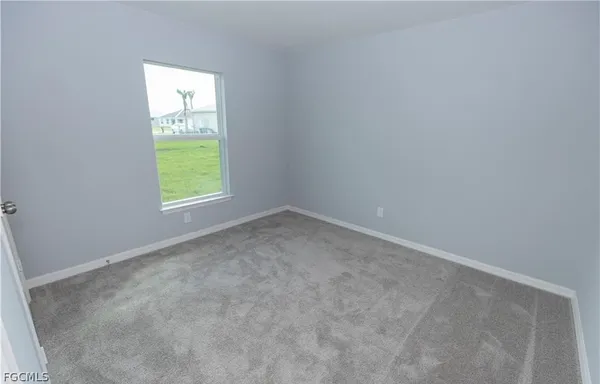 an empty room with a window and a mirror