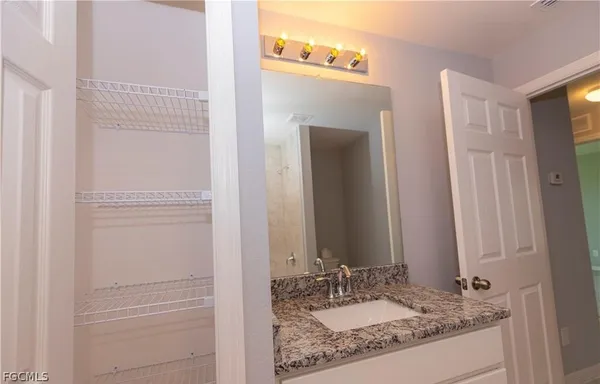 a bathroom with a granite countertop sink and a mirror