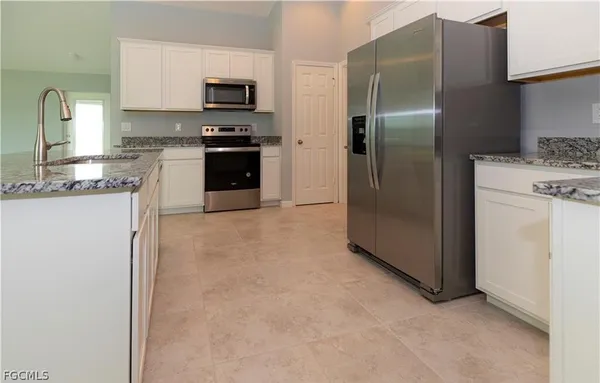 a kitchen with stainless steel appliances granite countertop a refrigerator and a stove