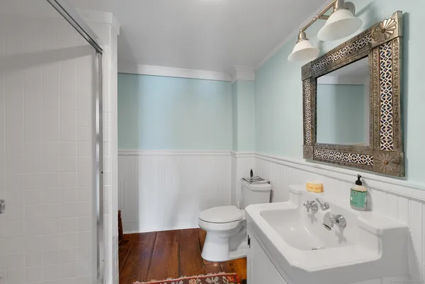 a bathroom with a sink a toilet and a mirror