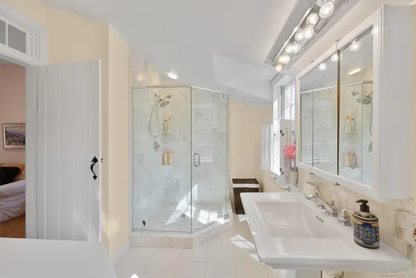 a bathroom with a shower sink and mirror