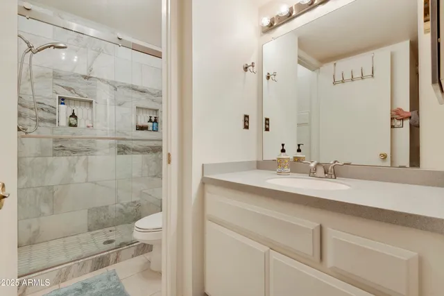 a bathroom with a shower sink and mirror