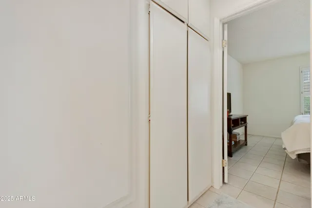 a view of a hallway with closet and a bathroom
