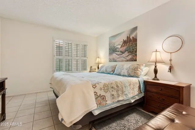 a bedroom with a bed and window with lamp