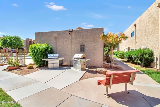 a backyard of a house with fountain table and chairs