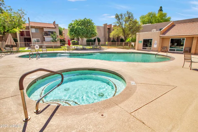 a view of swimming pool with outdoor seating and house in the background