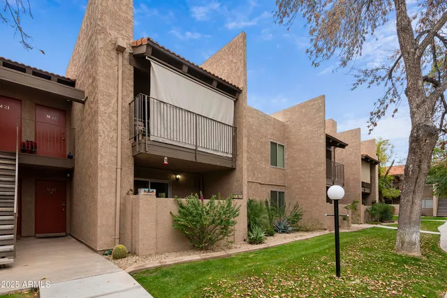 a view of a brick house with a yard and plants