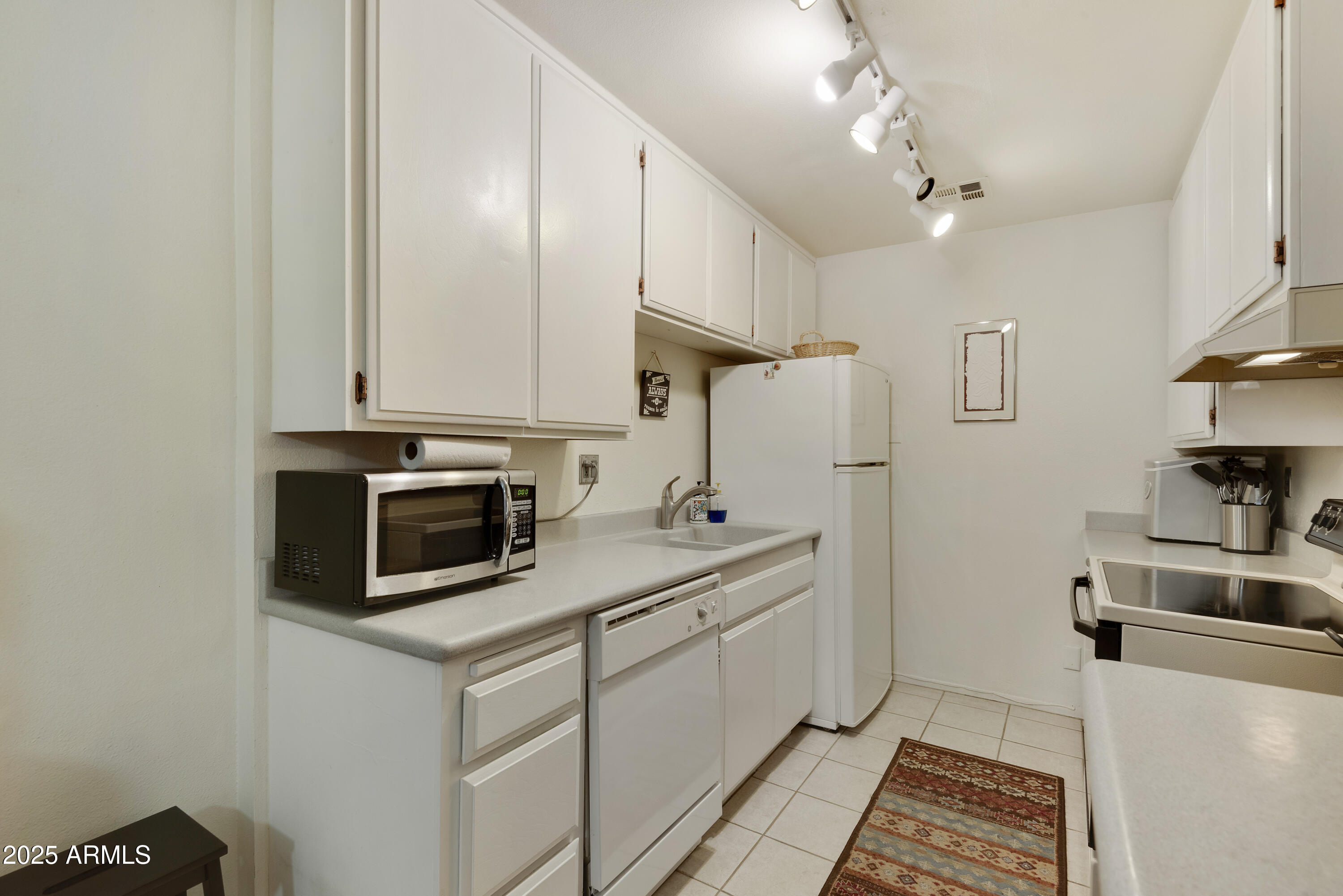 5525 East Thomas Road, Unit M16 Phoenix, AZ 85018 - Photo 9 of 27 a kitchen with stainless steel appliances a stove a sink and cabinets