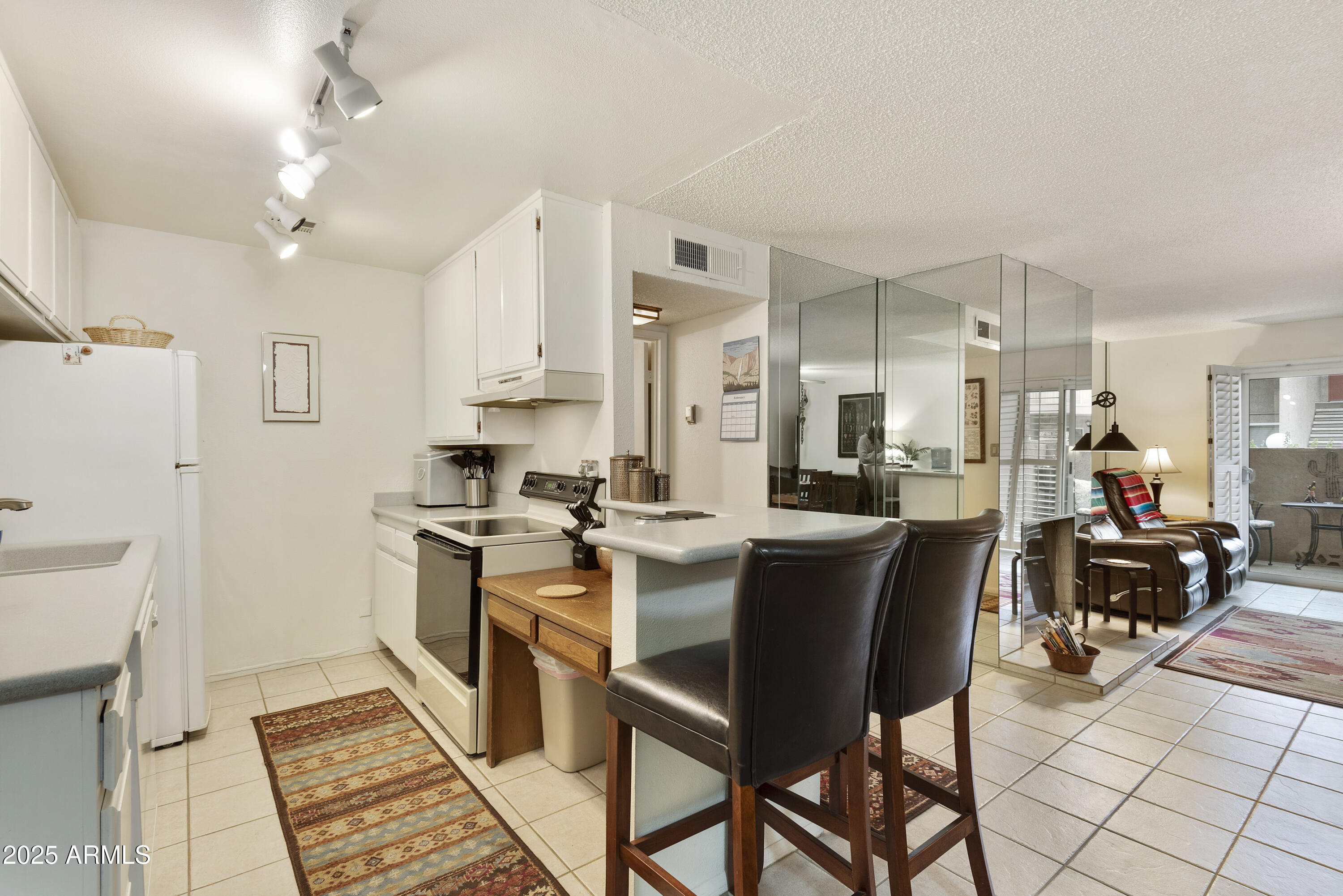 5525 East Thomas Road, Unit M16 Phoenix, AZ 85018 - Photo 10 of 27 a kitchen with stainless steel appliances kitchen island granite countertop a sink and cabinets