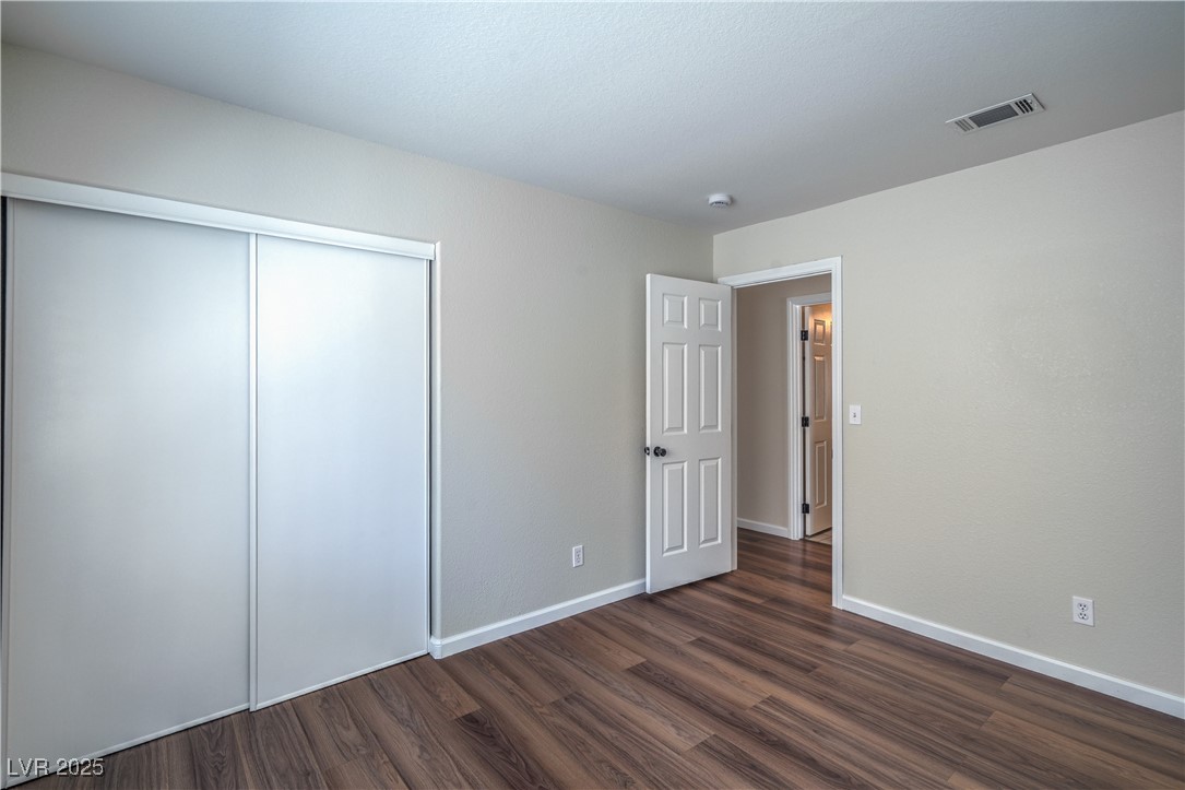 818 Coastal Beach Road Henderson, NV 89002 - Photo 27 of 39 Guest bedroom with dark wood finished floors and a closet