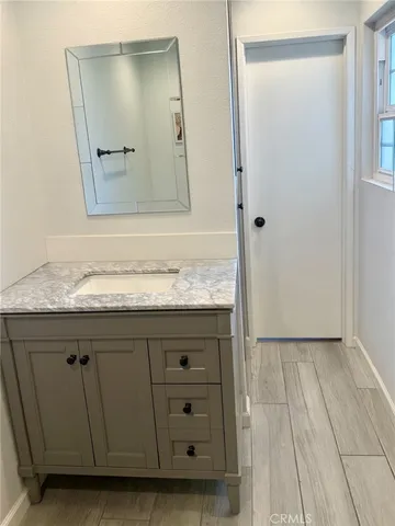a bathroom with a granite countertop sink and a mirror