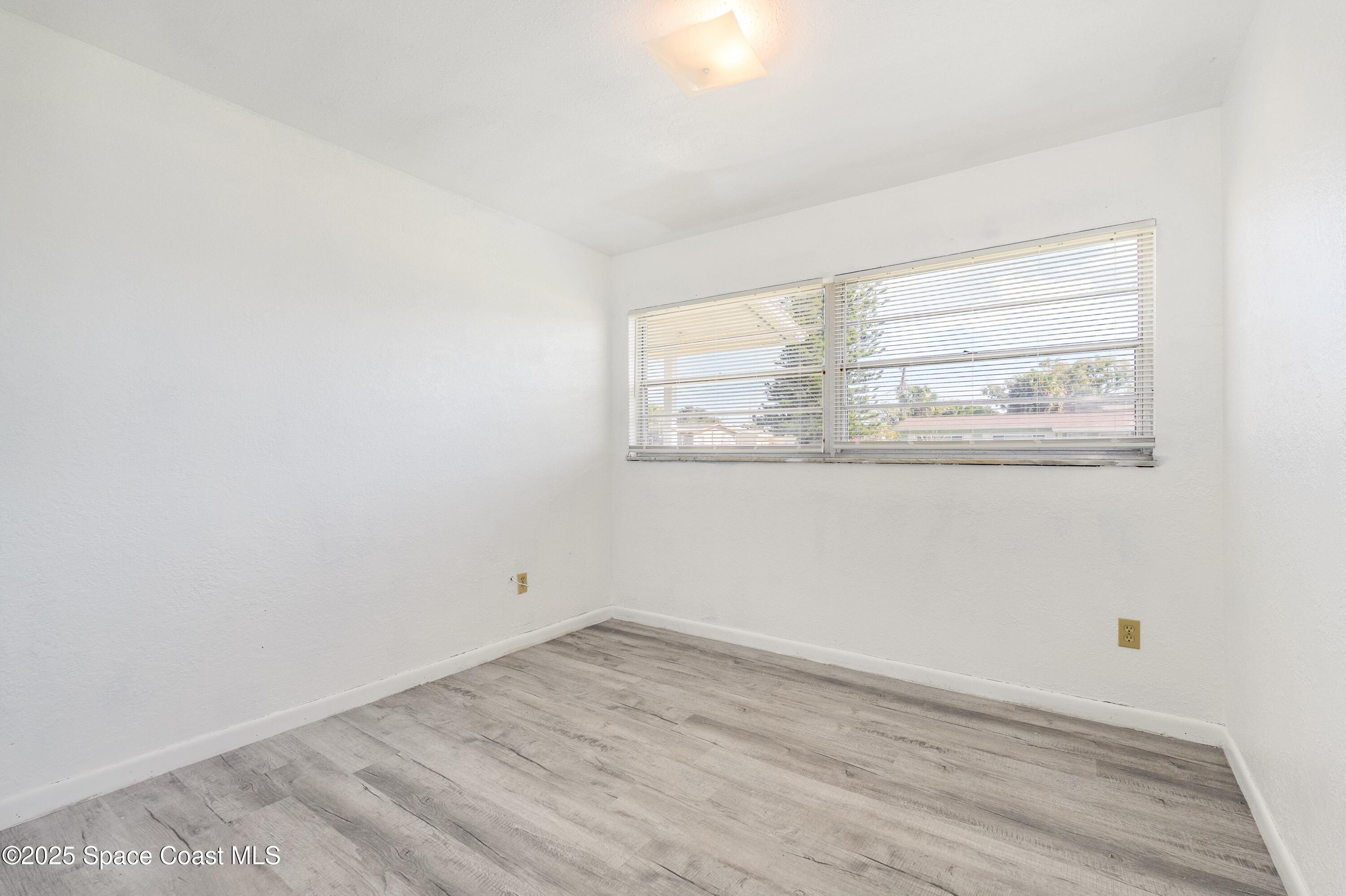 557 Cox Street Cocoa, FL 32926 - Photo 11 of 20 an empty room with wooden floor and windows