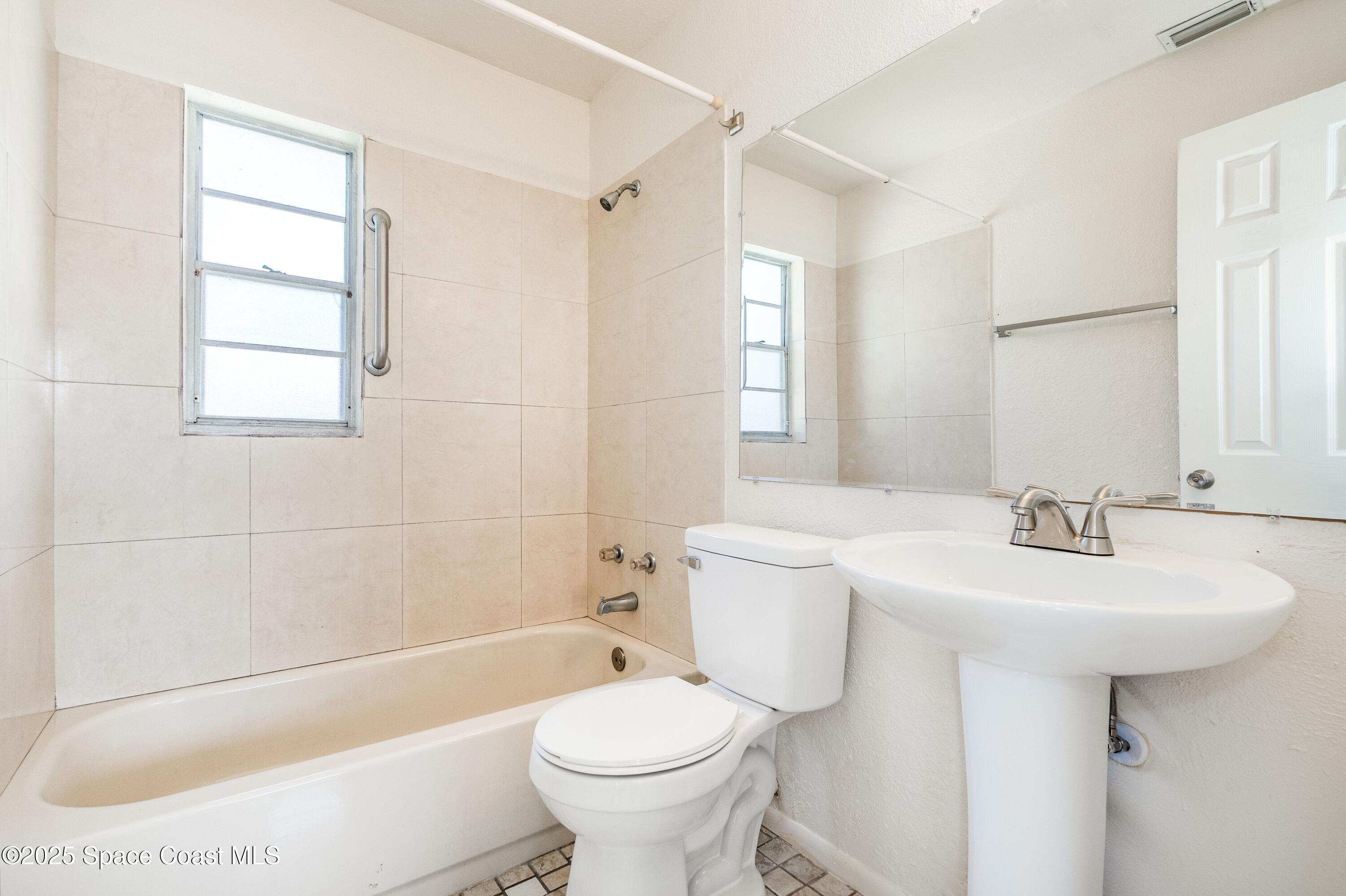 557 Cox Street Cocoa, FL 32926 - Photo 13 of 20 a bathroom with a sink toilet and shower