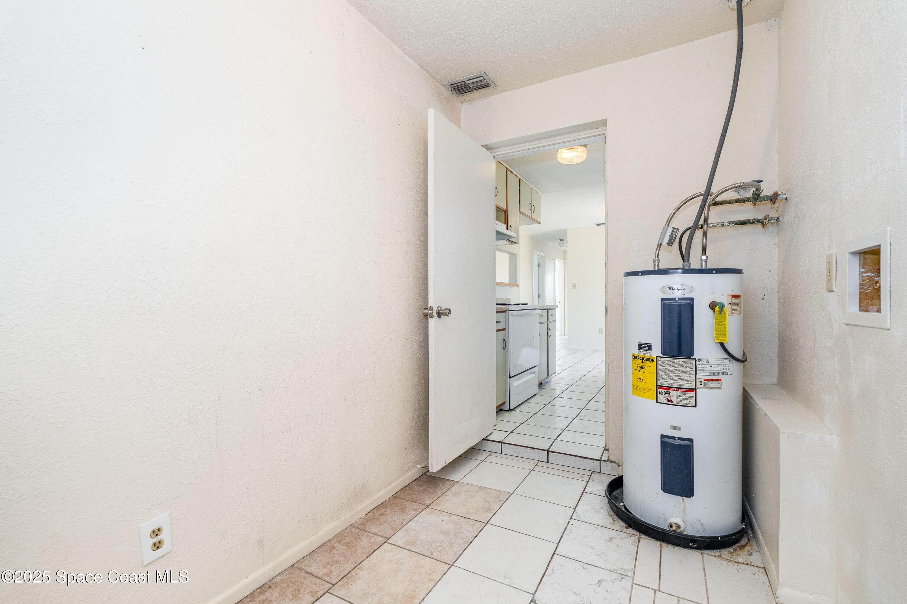 557 Cox Street Cocoa, FL 32926 - Photo 17 of 20 a hallway with a refrigerator and mirror