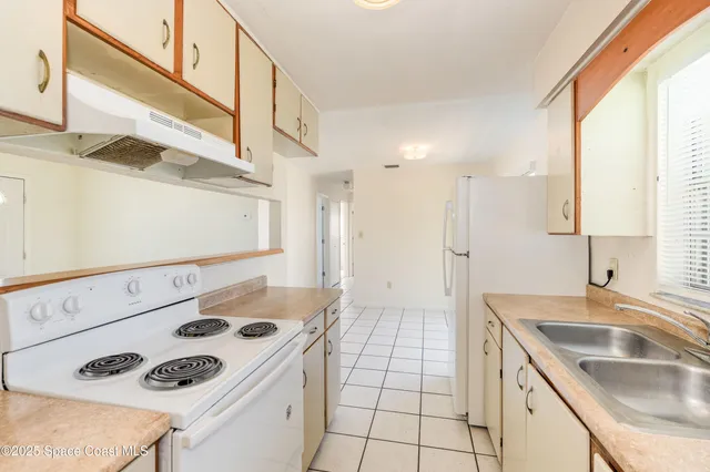 a kitchen with a sink a stove and a refrigerator