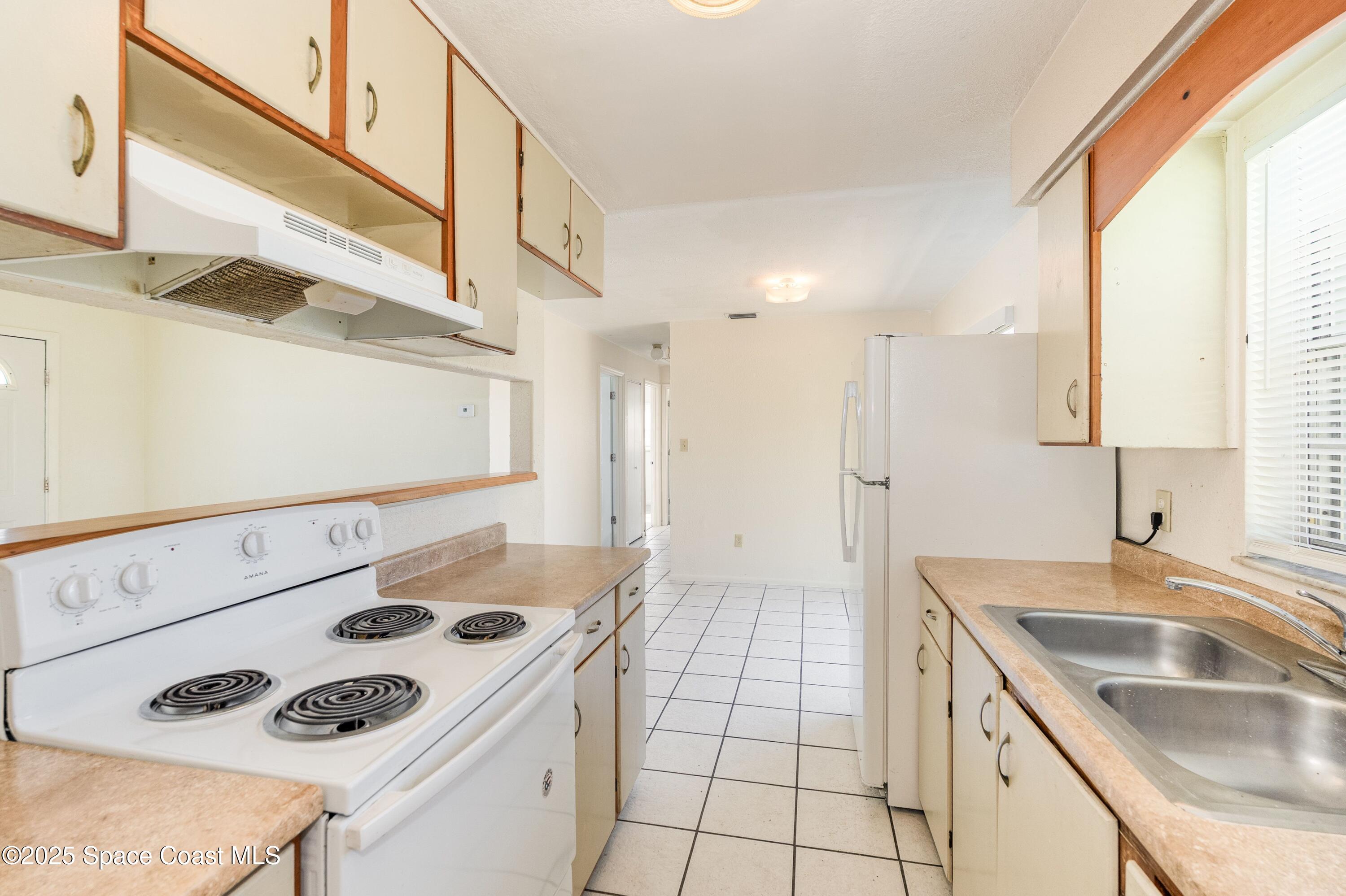 557 Cox Street Cocoa, FL 32926 - Photo 6 of 20 a kitchen with a sink a stove and a refrigerator