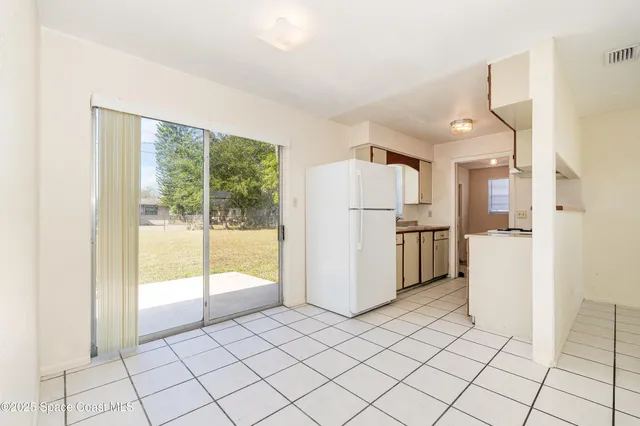 a kitchen with white cabinets and refrigerator