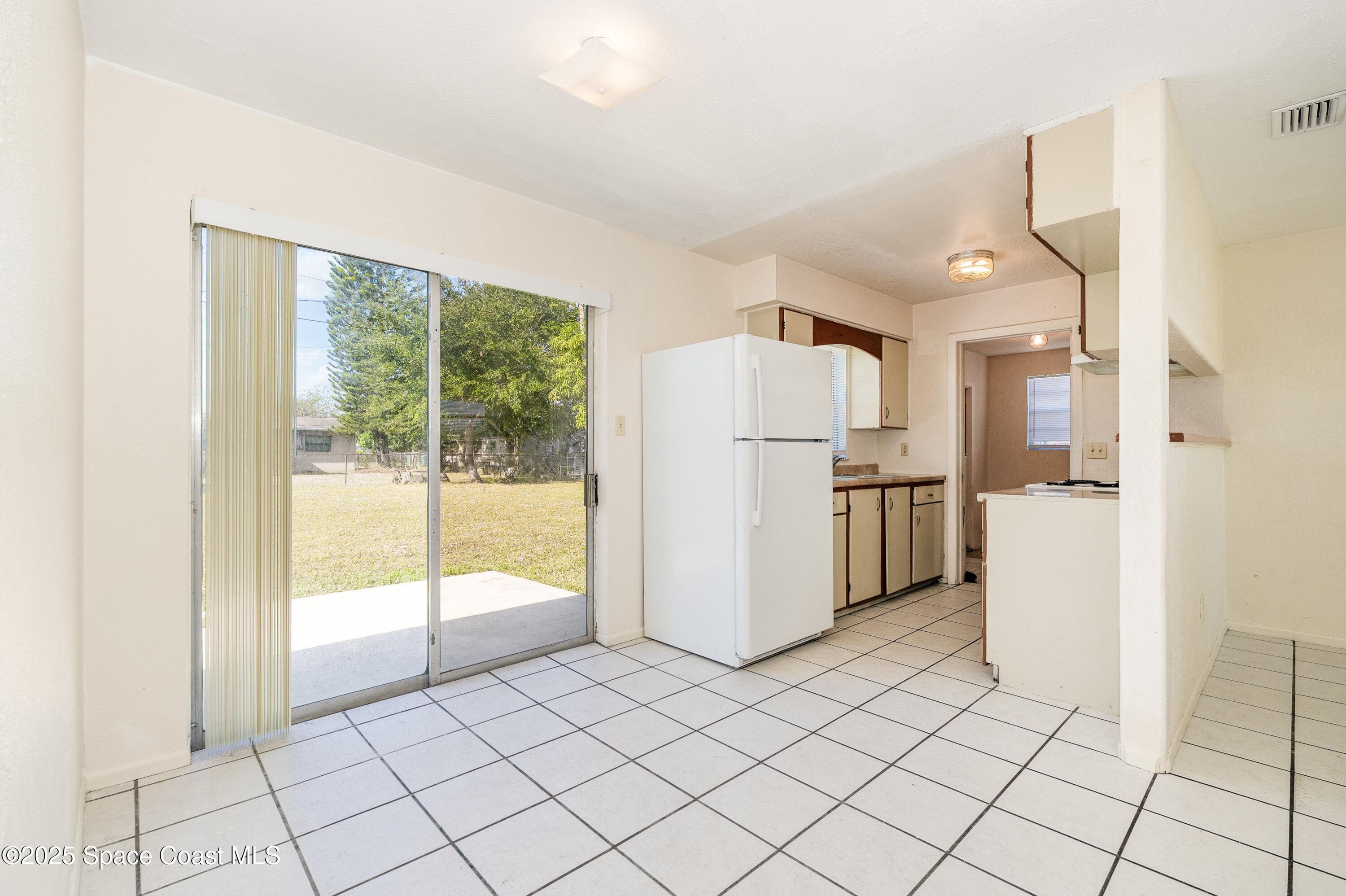 557 Cox Street Cocoa, FL 32926 - Photo 7 of 20 a kitchen with white cabinets and refrigerator