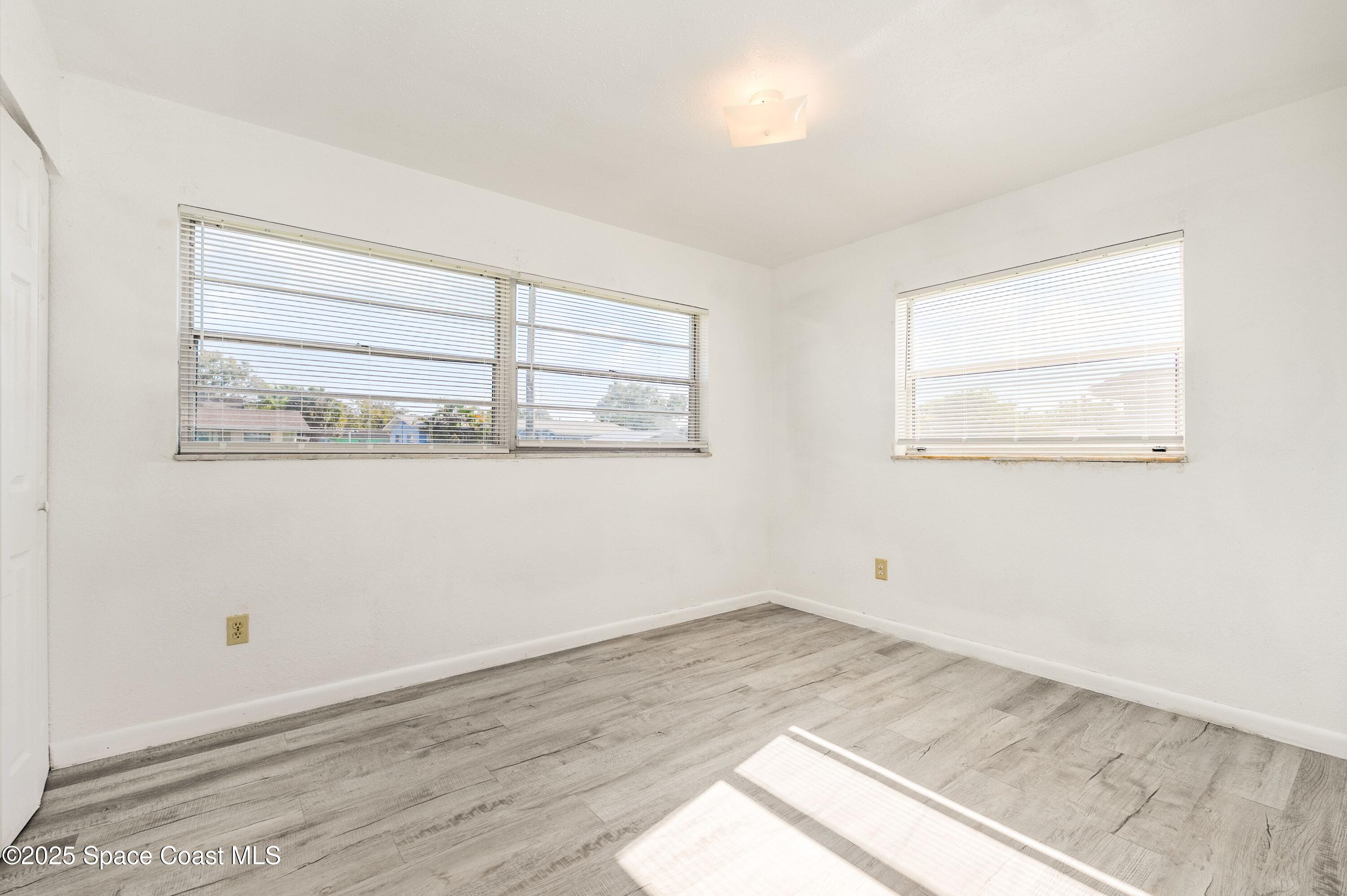 557 Cox Street Cocoa, FL 32926 - Photo 9 of 20 an empty room with wooden floor and windows