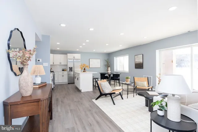 a living room with furniture and a dining table with wooden floor