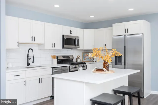 a kitchen with appliances a sink cabinets and a counter top space
