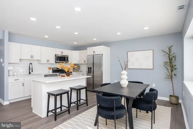 a kitchen with kitchen island a dining table and chairs