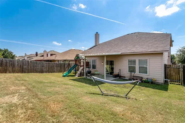 a backyard of a house with table and chairs