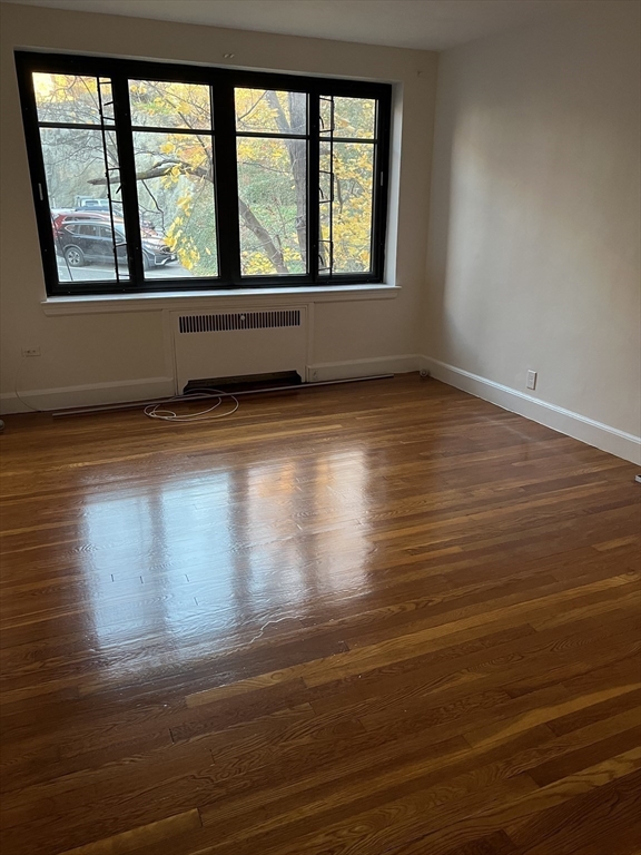 65 Strathmore Road, Unit 31 Boston, MA 02135 - Photo 2 of 7 an empty room with wooden floor and windows