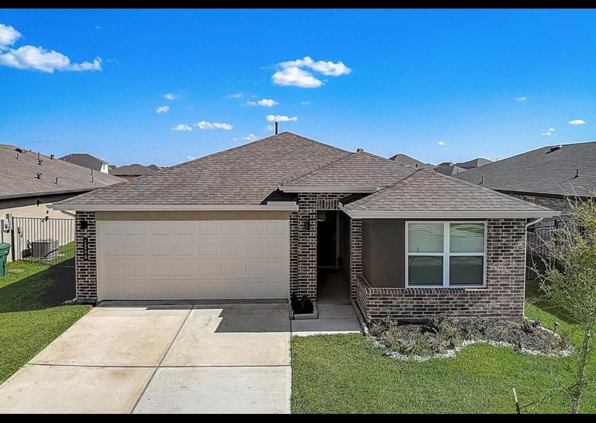1246 Truckee River Drive Rosharon, TX 77583 - Photo 1 of 23 This photo shows a modern, single-story brick home with a two-car garage, a well-maintained lawn, and a simple driveway. It features a clean exterior with a small garden area and is set in a suburban neighborhood.