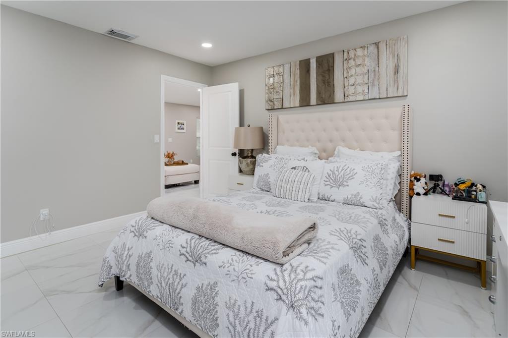 5170 19th Court Southwest Naples, FL 34116 - Photo 14 of 32 a bedroom with a bed and a couch