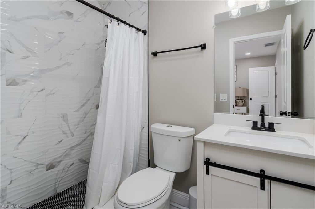 5170 19th Court Southwest Naples, FL 34116 - Photo 15 of 32 a bathroom with a sink a toilet a mirror and shower