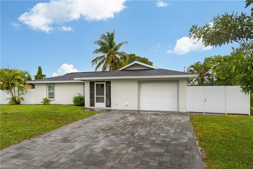 5170 19th Court Southwest Naples, FL 34116 - Photo 26 of 32 a front view of a house with a garden and yard