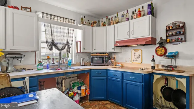 a kitchen with stainless steel appliances a sink a stove and a wooden floor