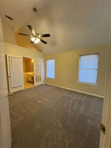 a view of a livingroom with a chandelier fan and windows