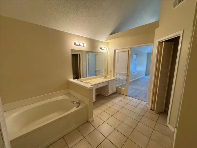 a bathroom with a tub a sink and a mirror