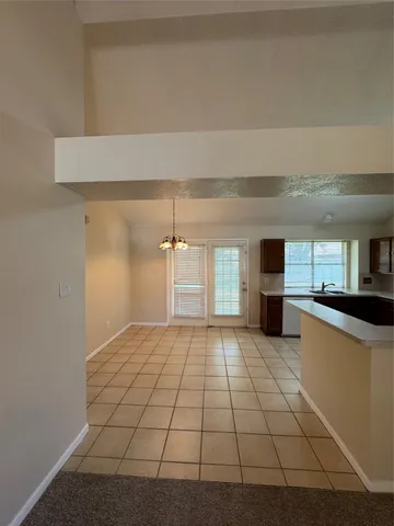 a view of kitchen with cabinets and window