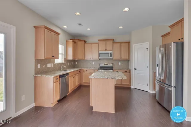 a kitchen with a refrigerator stove microwave and cabinets