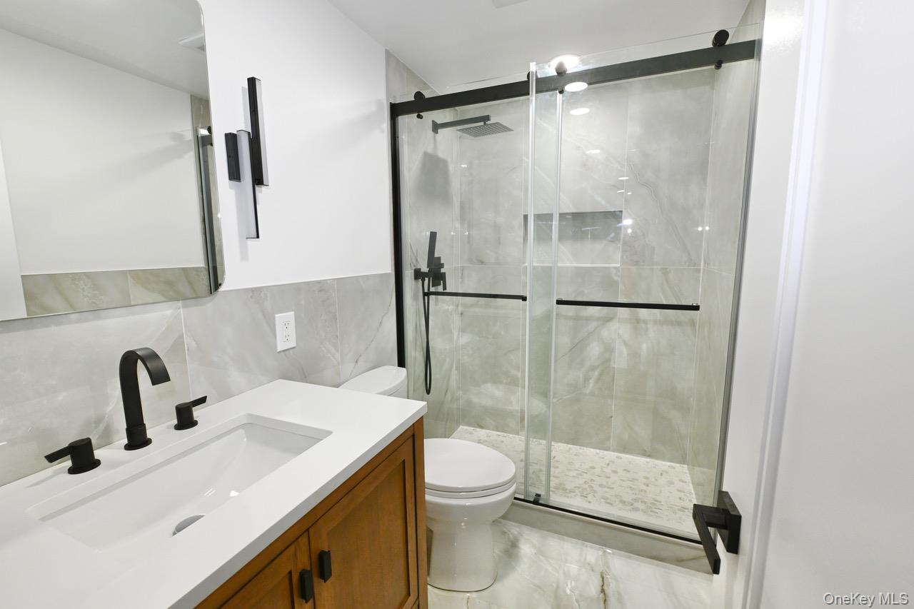 2 Little Hill East Setauket, NY 11733 - Photo 18 of 22 a bathroom with a shower sink vanity mirror and toilet