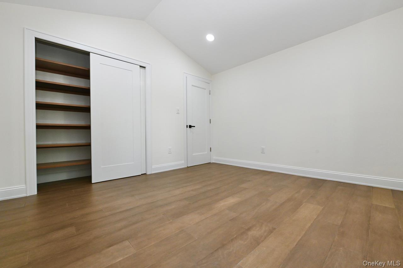 2 Little Hill East Setauket, NY 11733 - Photo 19 of 22 a view of an empty room with a window and wooden floor