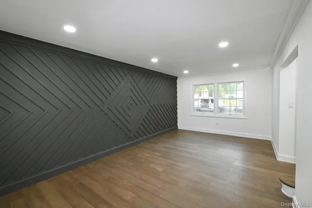 a view of empty room with wooden floor and fireplace