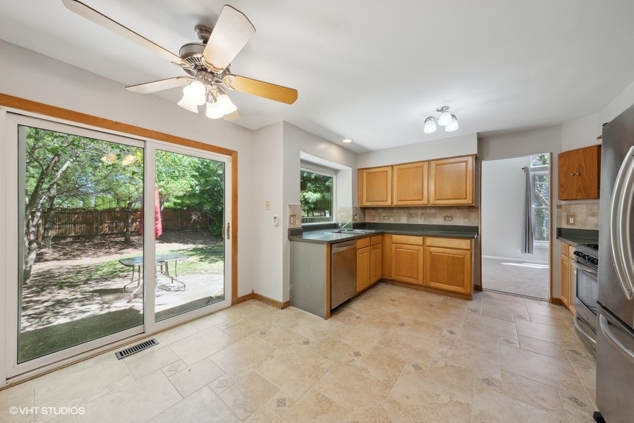 1824 Red Bud Road Bolingbrook, IL 60490 - Photo 5 of 22 a kitchen with a chandelier stainless steel appliances and a large window