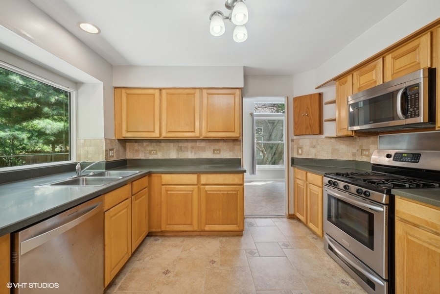 1824 Red Bud Road Bolingbrook, IL 60490 - Photo 6 of 22 a kitchen with stainless steel appliances granite countertop a stove sink and cabinets