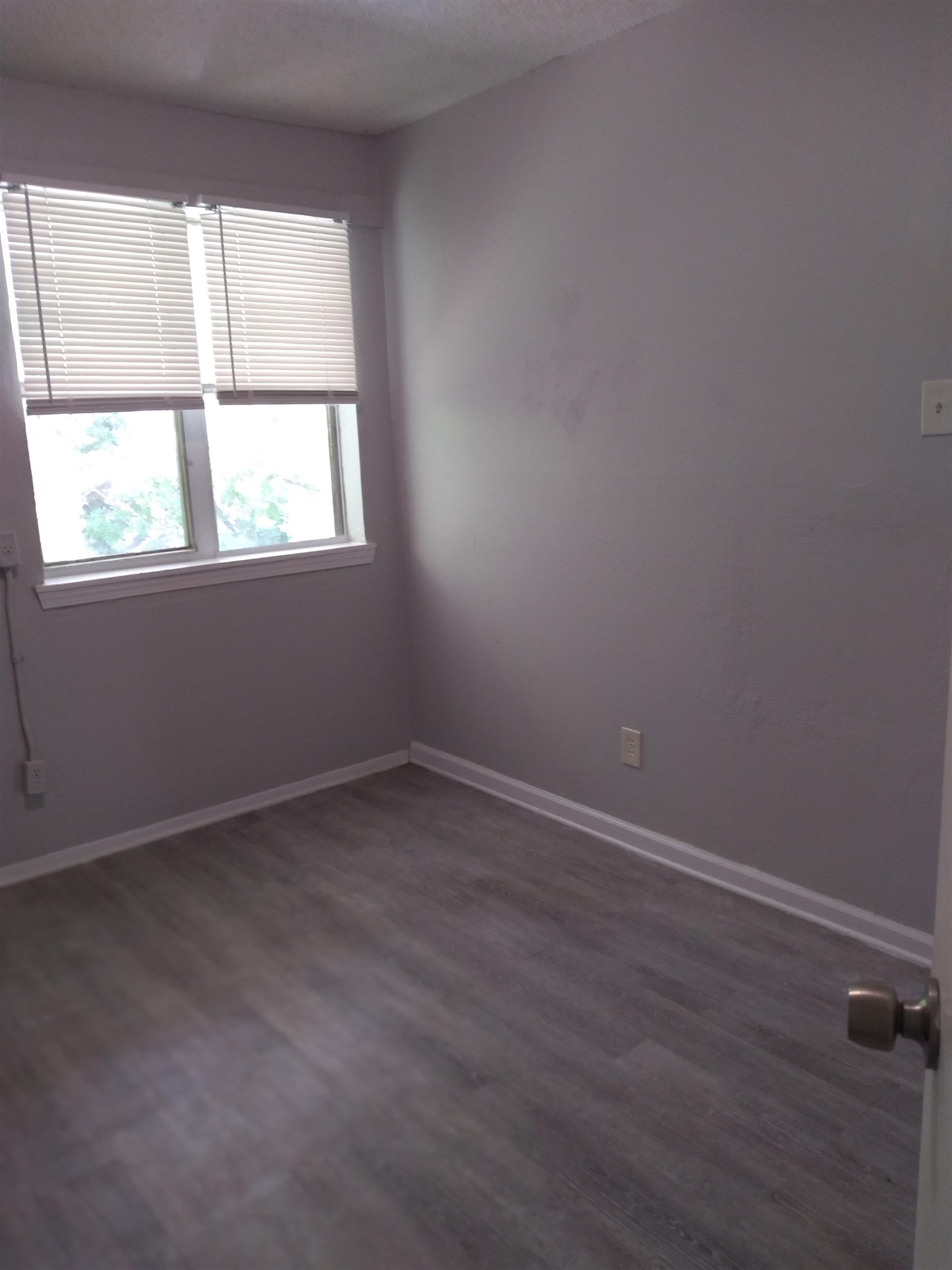 2116 Howell Avenue Memphis, TN 38108 - Photo 3 of 5 Empty room with dark wood finished floors and a textured ceiling