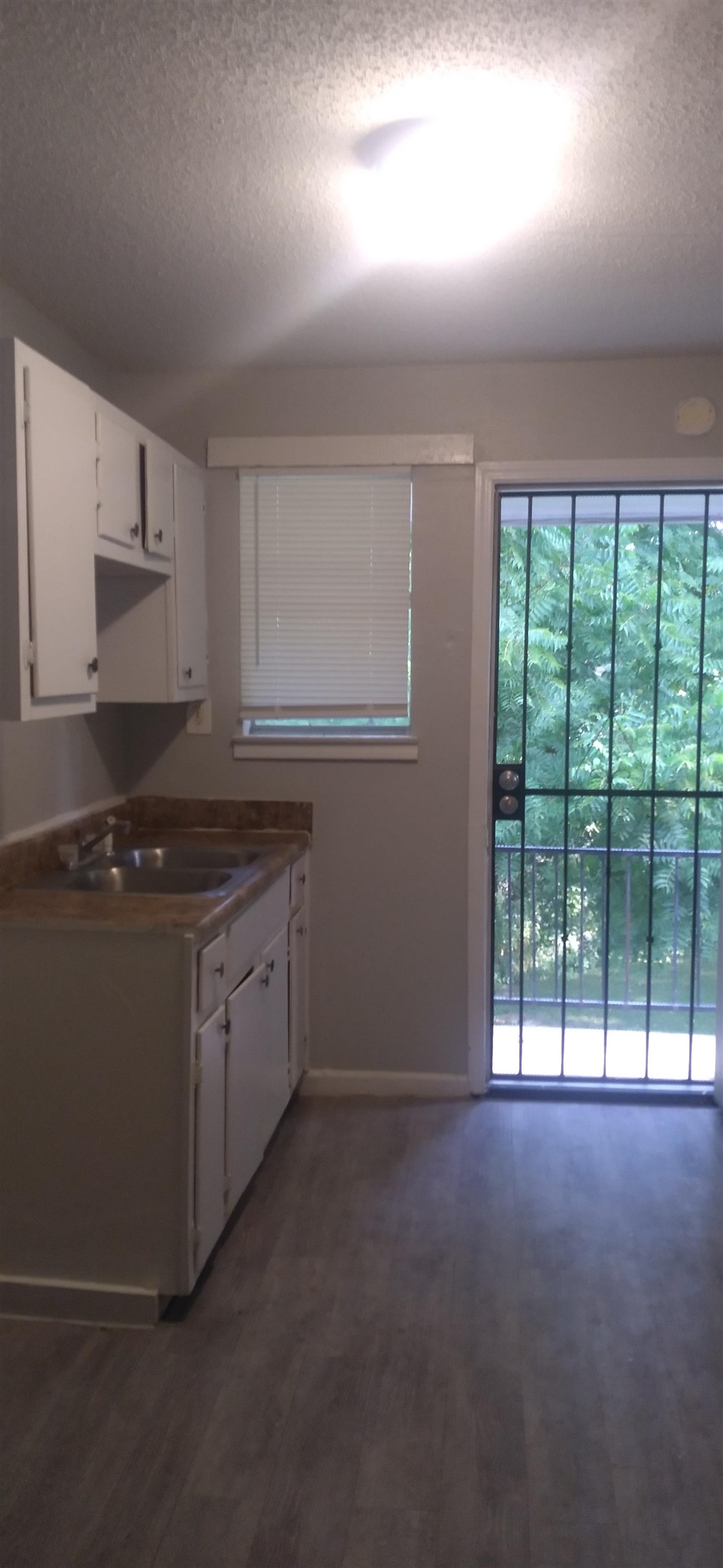2116 Howell Avenue Memphis, TN 38108 - Photo 5 of 5 Kitchen with white cabinetry, a textured ceiling, dark countertops, and dark wood-style floors