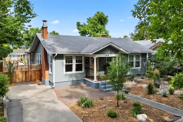 a view of an empty room with wooden floor fireplace and a window