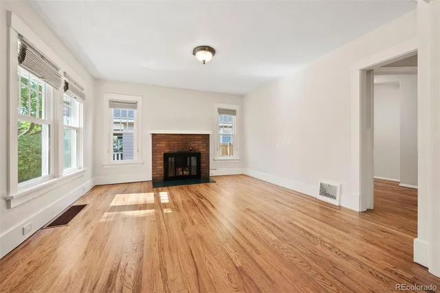 a view of empty room with wooden floor and fireplace
